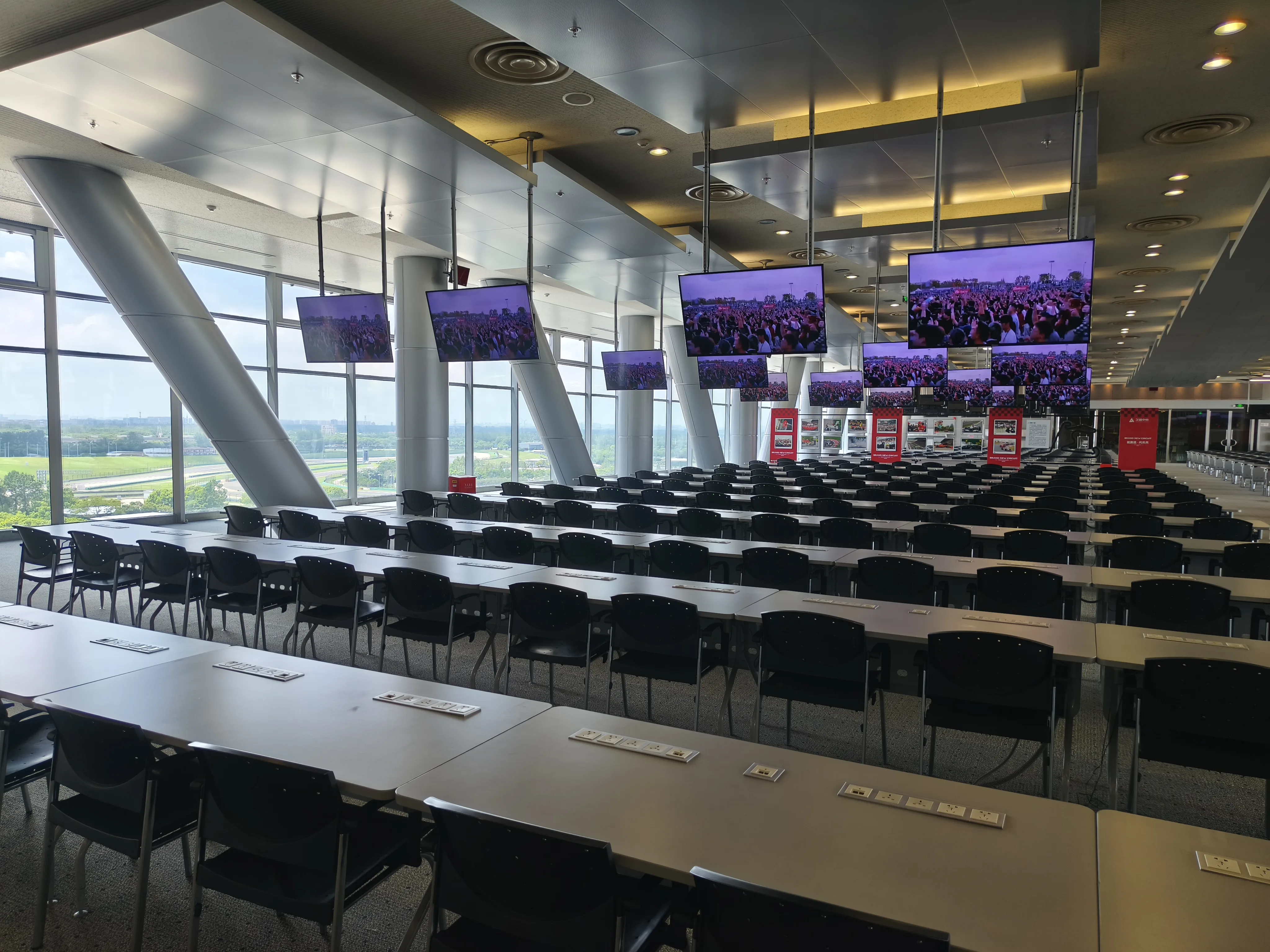 Large briefing room at a Chinese automotive facility with screens and rows of seats