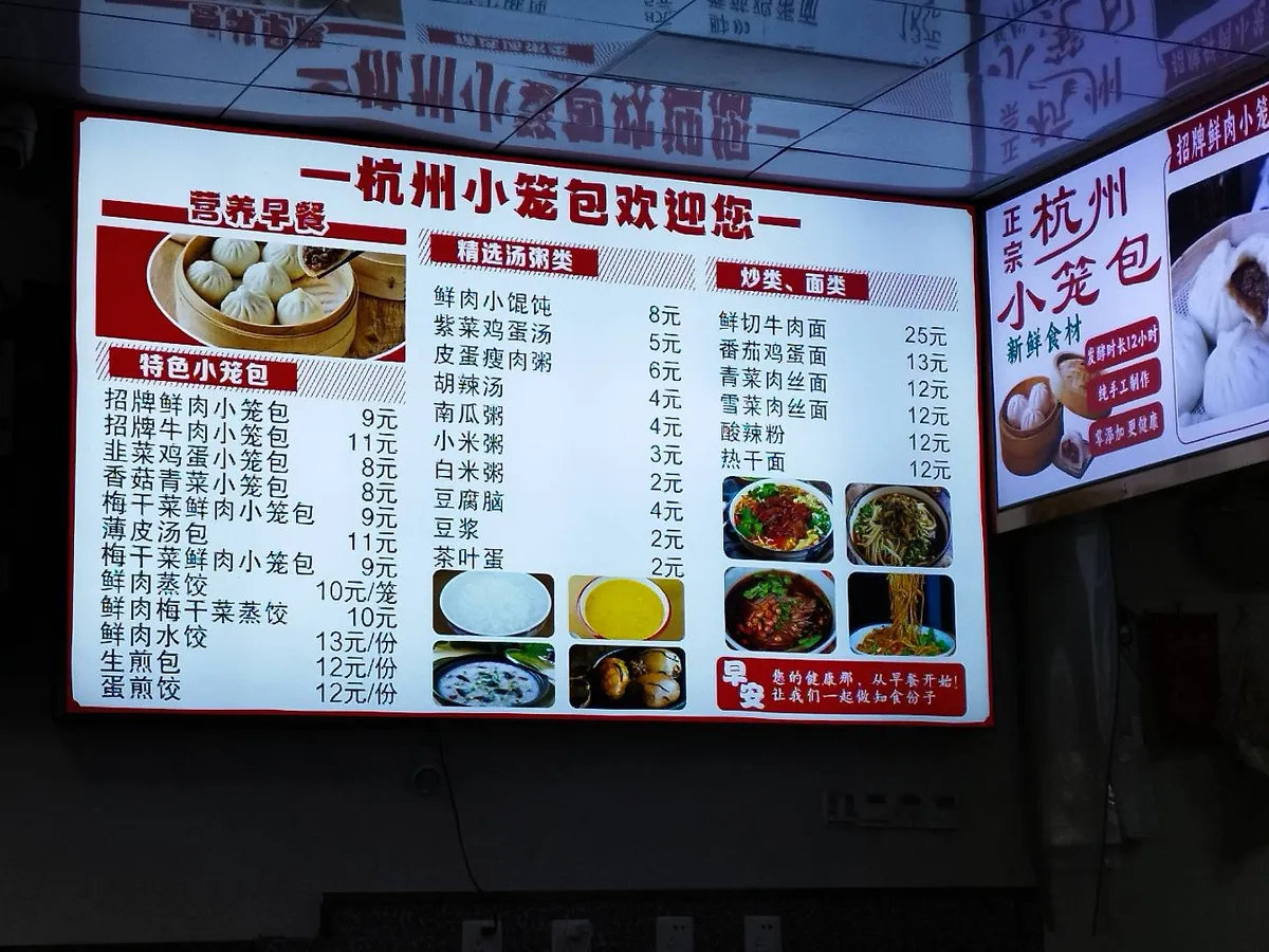 Hangzhou xiaolongbao restaurant menu board in Chinese showing dumpling and porridge options with prices in yuan