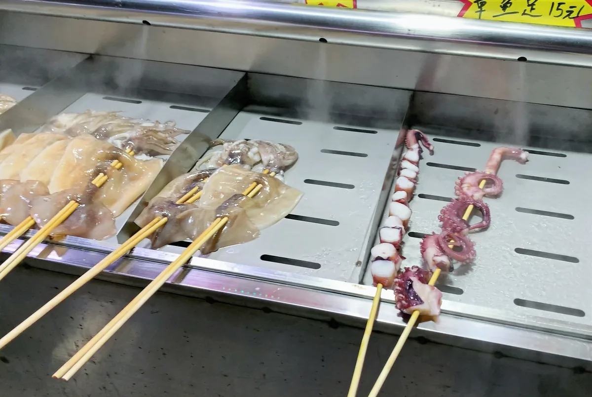 Squid and octopus on skewers being grilled