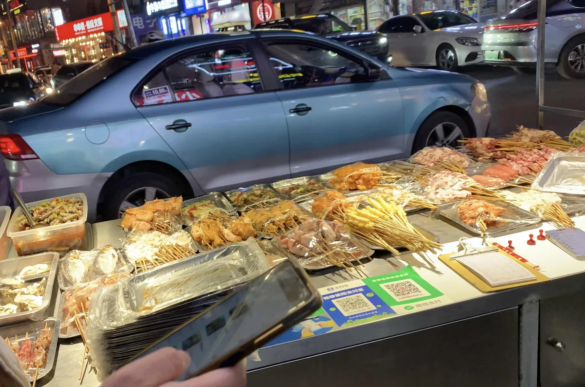 Dalian BBQ stall with QR code payment and raw seafood on display