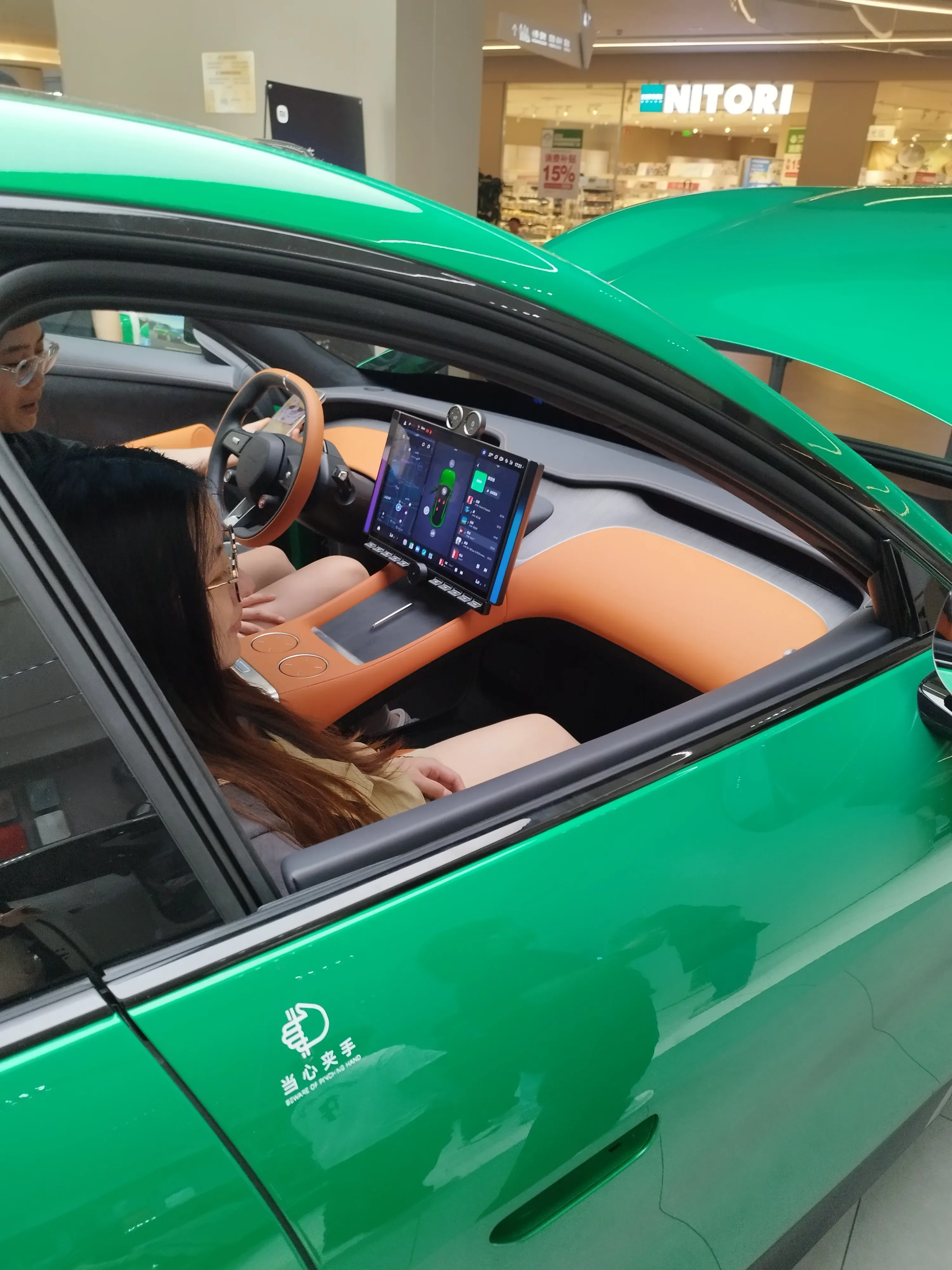 Bright green car with orange leather interior and rotating central screen