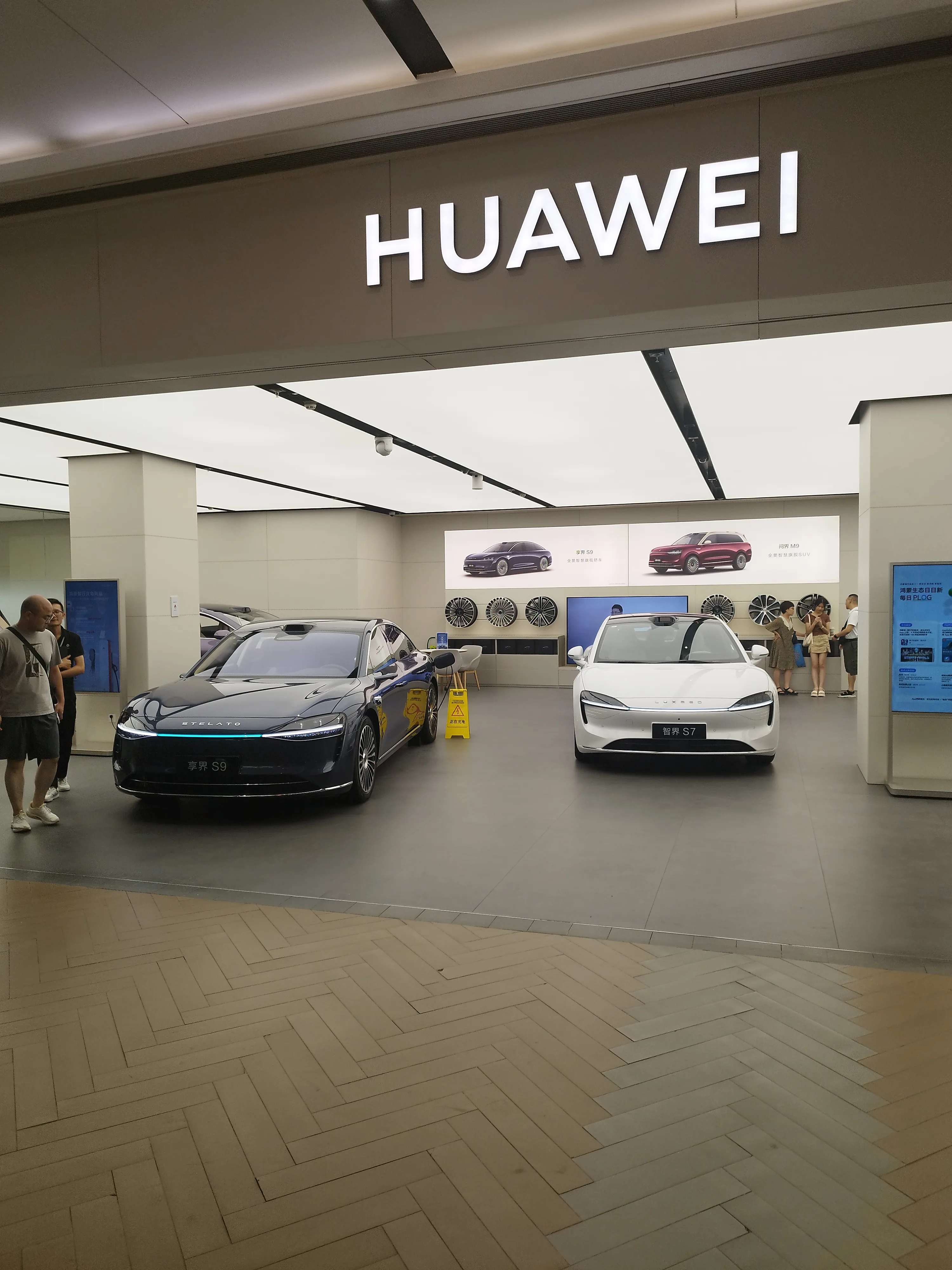 Huawei store in Shanghai showing two cars: 享界S9 and 智界S7